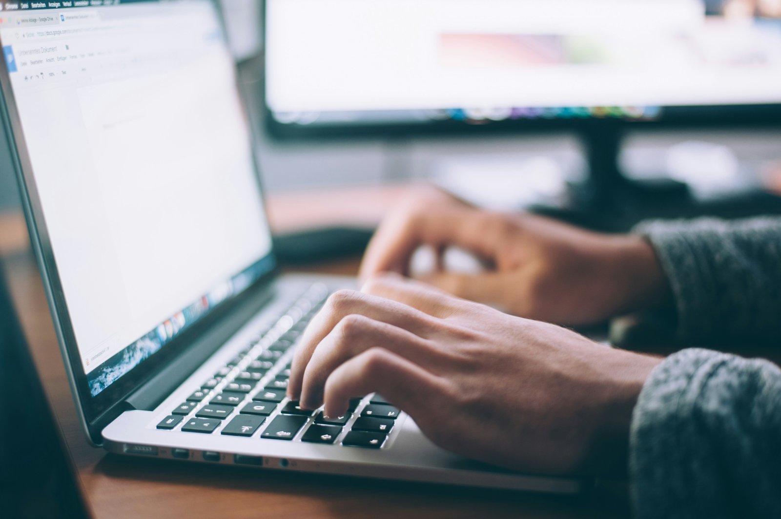 Close-up of fingers typing on a laptop keyboard